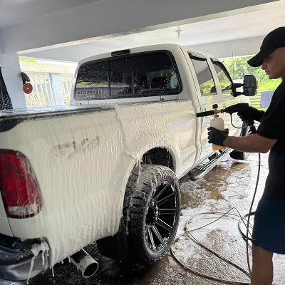 Persona limpiando el exterior de un auto